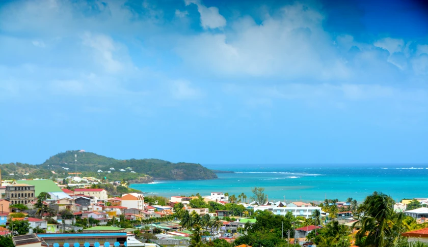 a town next to the ocean under a partly cloudy sky