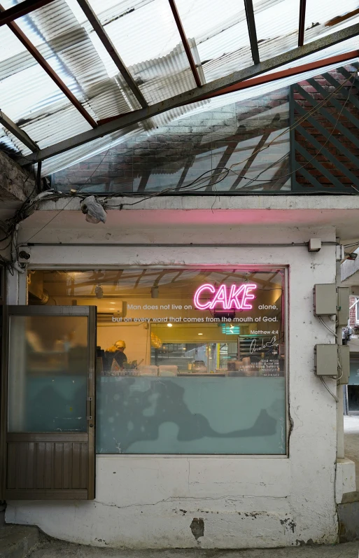 a pink sign is on a window in front of a shop