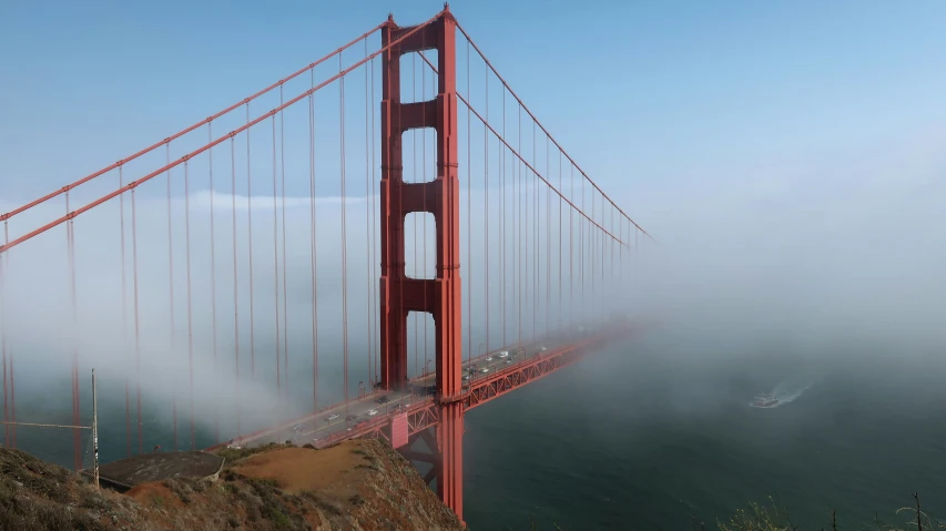 a long view of the golden gate bridge surrounded by fog