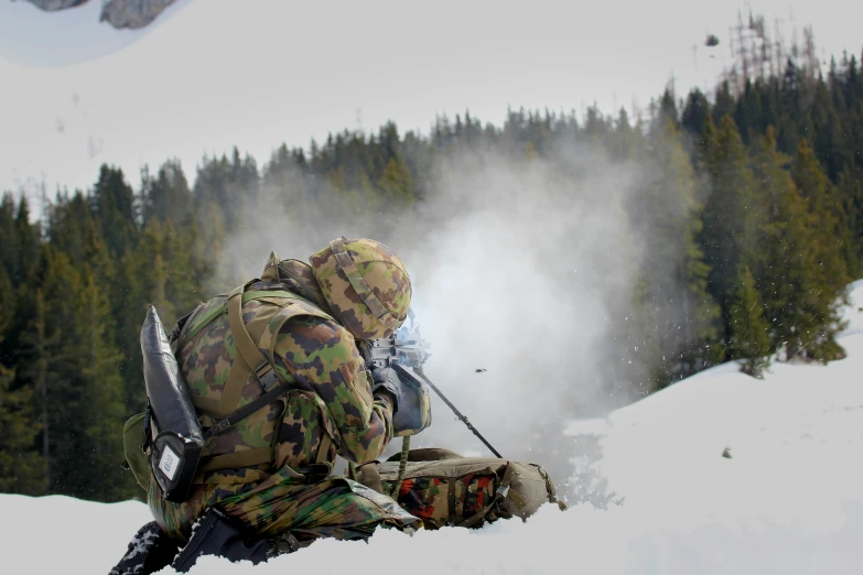 military man sitting on snow using trek equipment