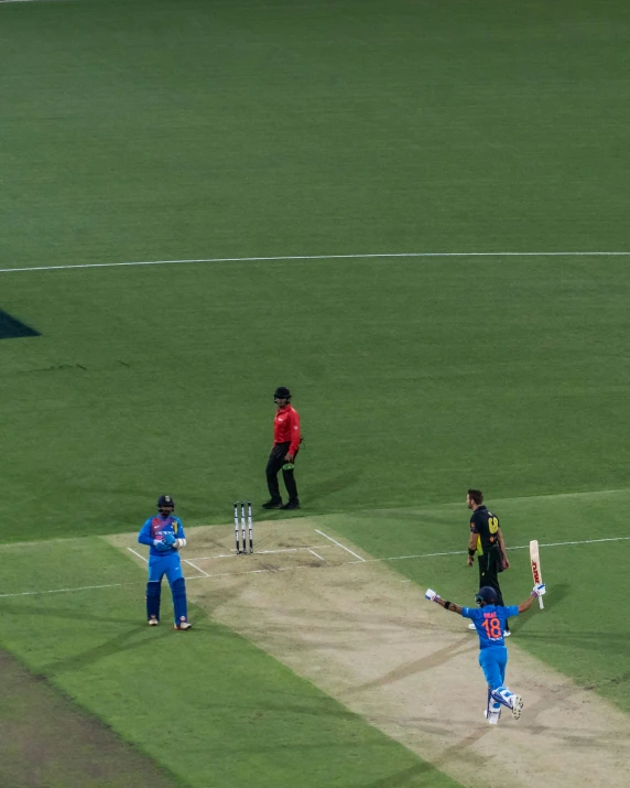 the three men are playing a game of cricket on the field