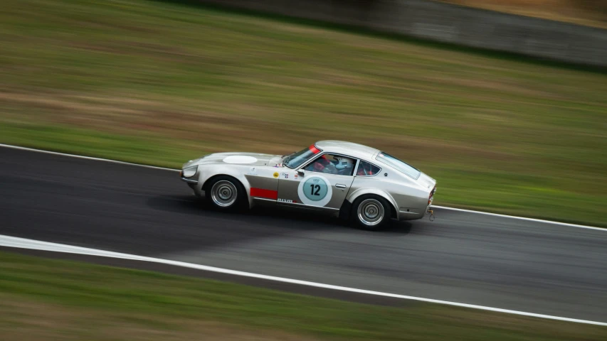 a vintage race car driving around a turn on a racing track