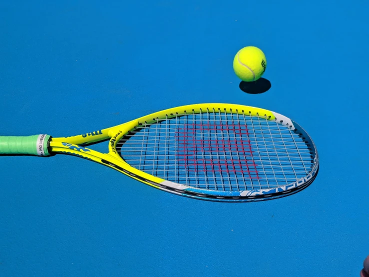 a close - up of a tennis racket with a ball on the ground