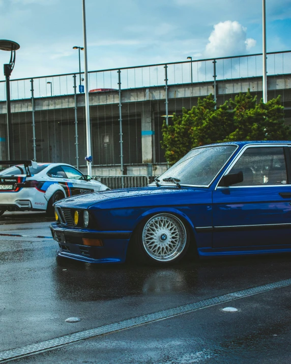 a blue car parked on the side of a road in a parking lot