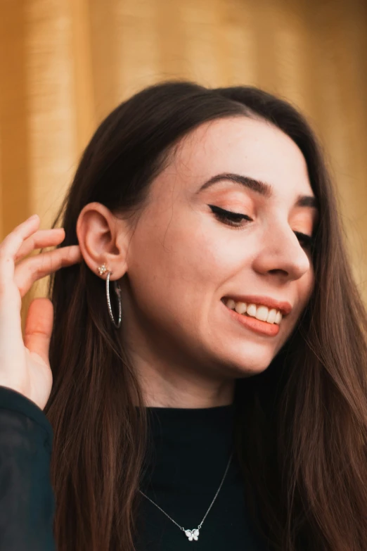 a young woman wearing a necklace with the word love is attached to her ear