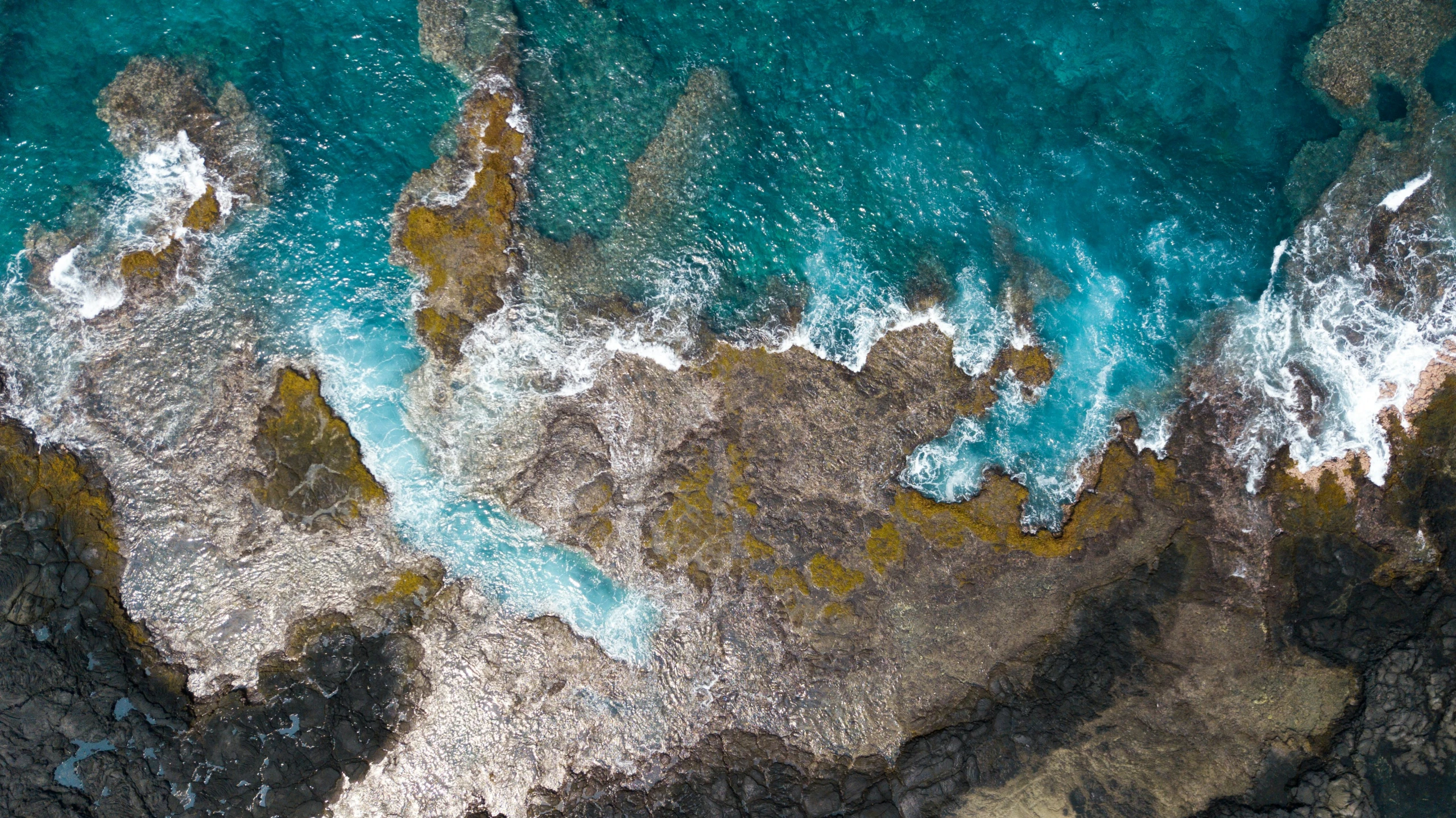 water that is sitting on the rocks near a beach