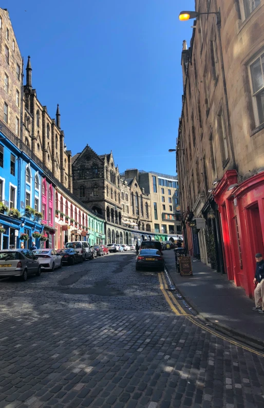 an empty street lined with colorful buildings and cobblestone roads