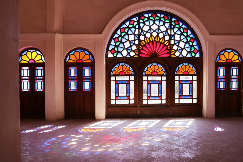 the sun is shining through three brightly stained glass windows