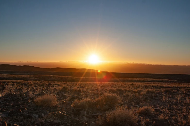 a beautiful sunrise in the distance with some mountains