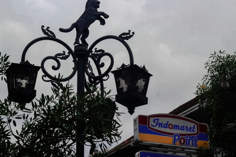 a light fixture stands in front of a large sign