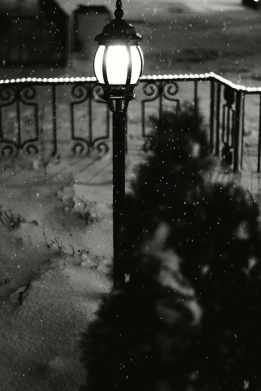 a street lamp stands by a street light in the dark