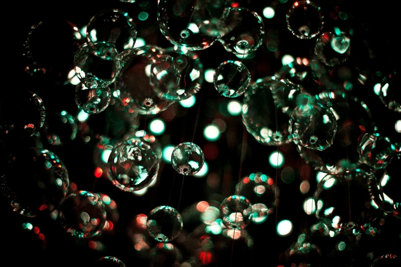 green bubbles of water float in the night sky