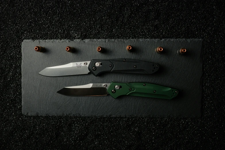 a set of knives laying on a black surface