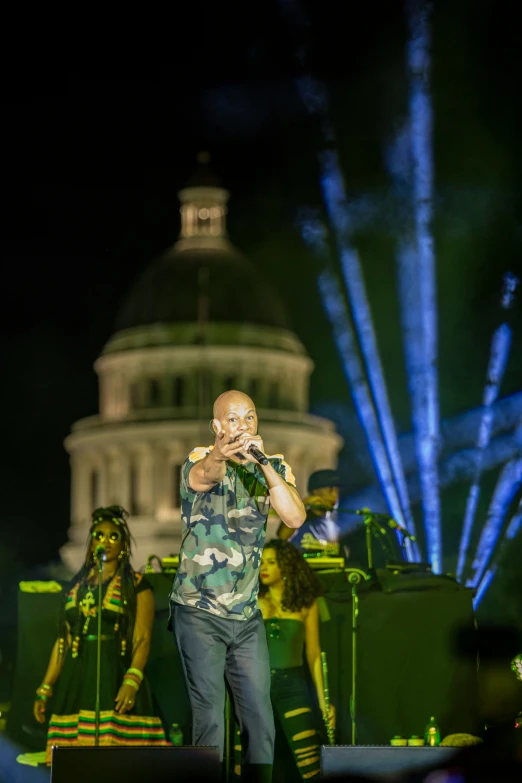 a man singing while people in concert gear watch