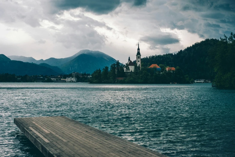 a dock with a mountain and a church in the background