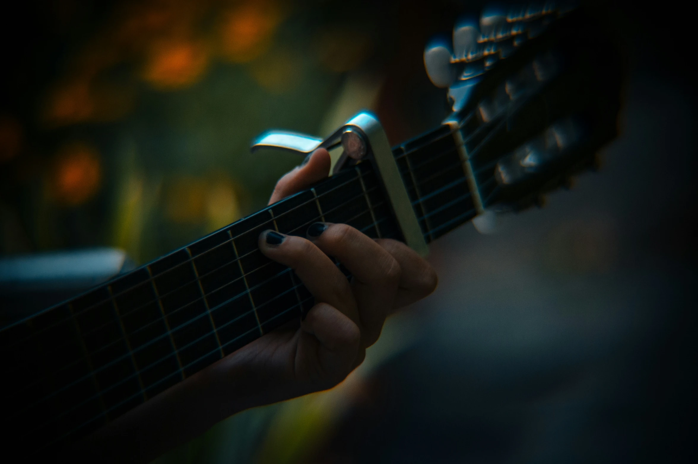 a person with a cell phone next to a guitar