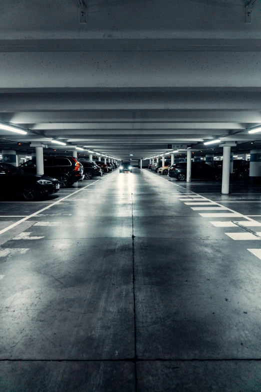 an empty parking garage filled with lots of parked cars