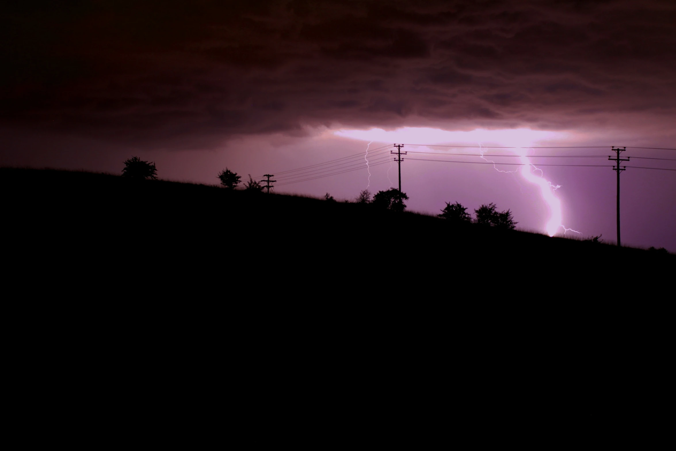 a lightning strikes at night with purple hues