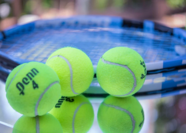 a group of tennis balls sitting on top of a blue racket