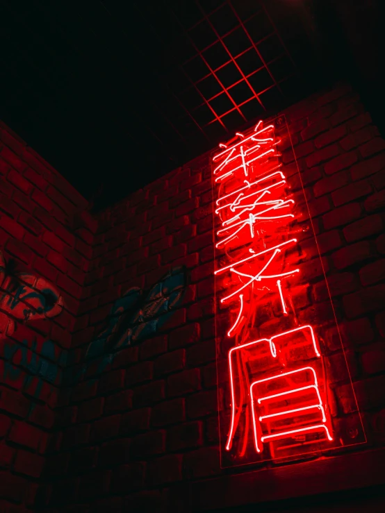 a large red neon sign on the side of a brick wall