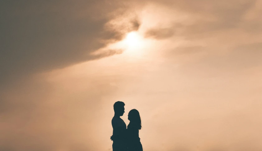 two people standing next to each other while holding hands