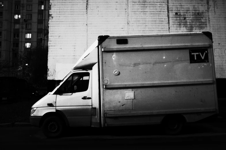 the back side of an empty utility vehicle in front of large building