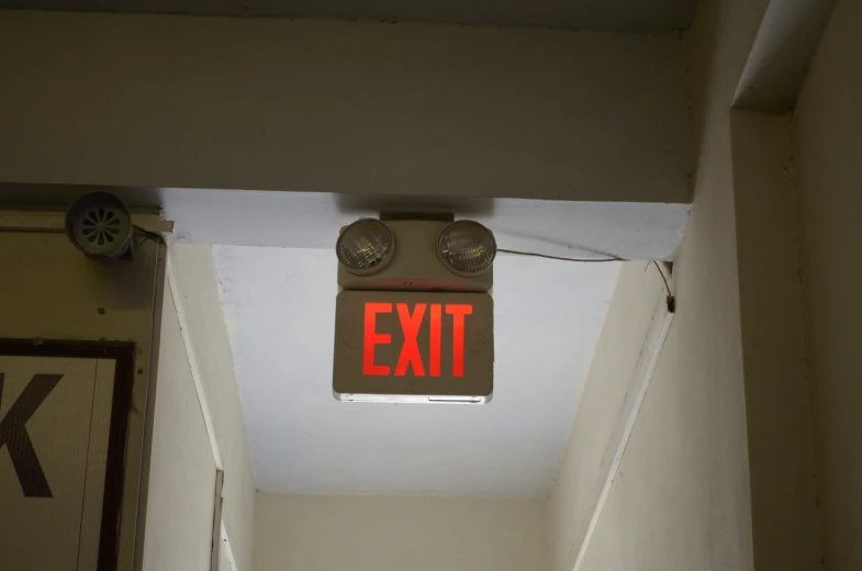 an exit sign in a doorway reads emergency