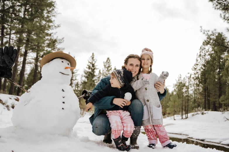 two women and a  pose beside a snowman