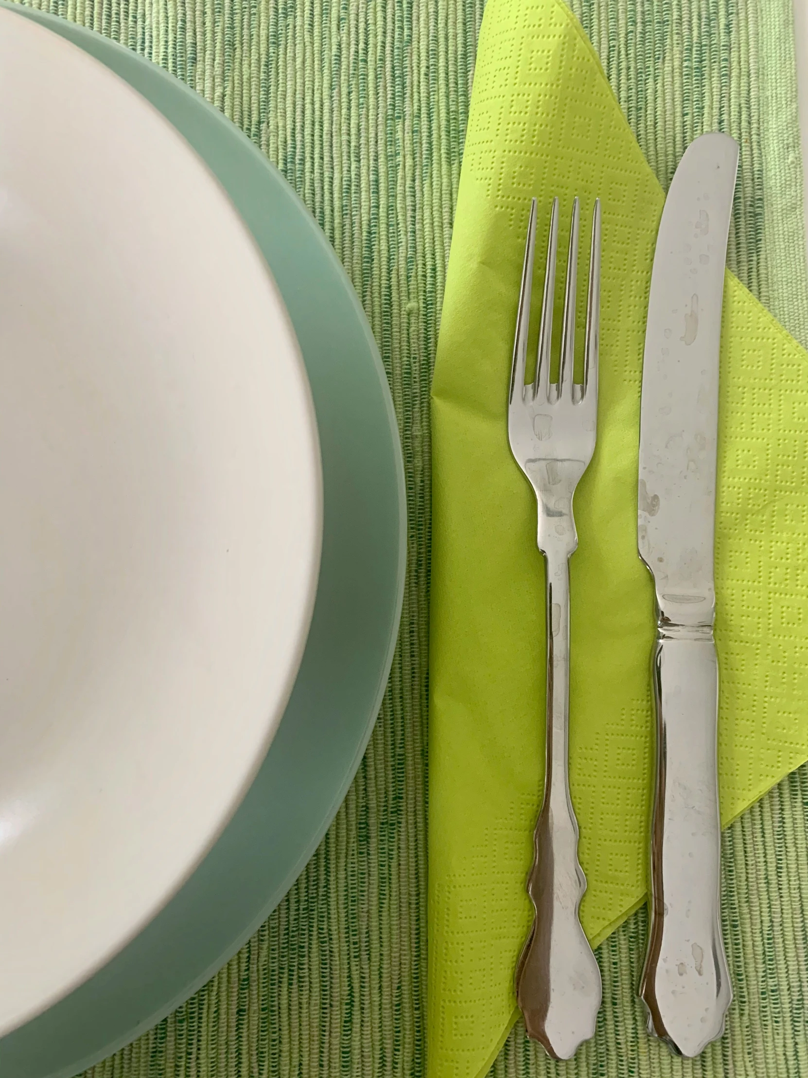 a view of silverware sitting on a green cloth