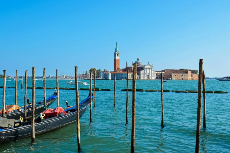 a gondola in a blue water with buildings in the background