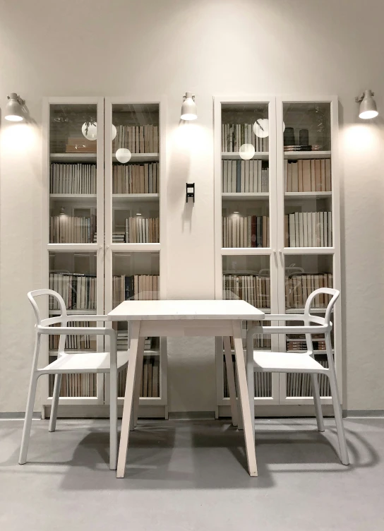 a table sitting on top of a white floor next to shelves of books