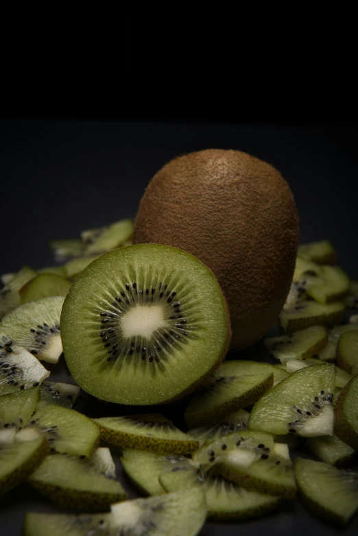 a kiwi and sliced kiwis laying on top of each other