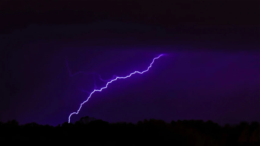 a purple lightning bolt on a night sky