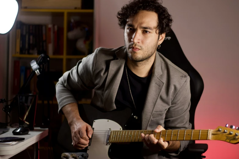 man holding electric guitar posing for picture with lights on background