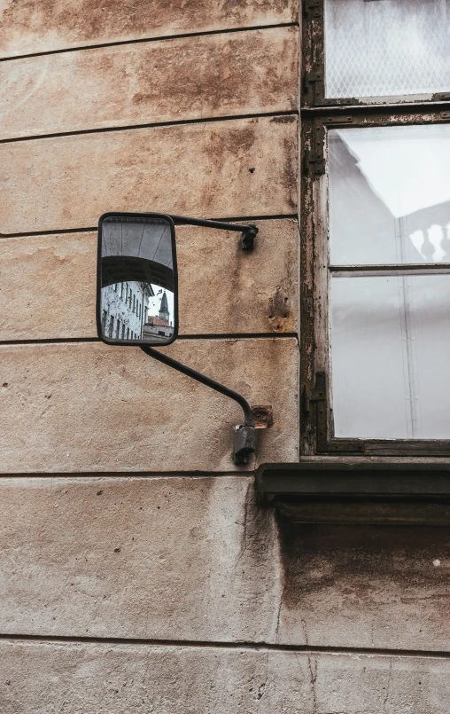 a mirror mounted to the side of a building