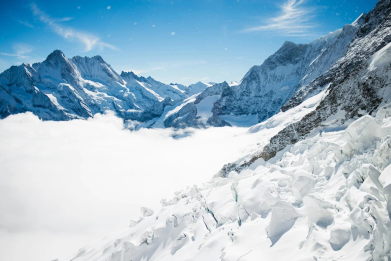 a mountain range covered in snow and clouds