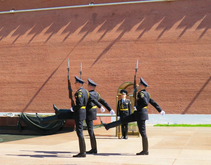 four men in uniforms are performing with flags