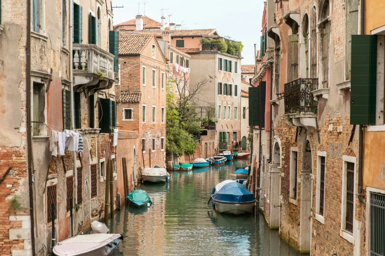 small boats that are on the water near some buildings