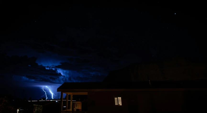 lightning over an area at night with trees