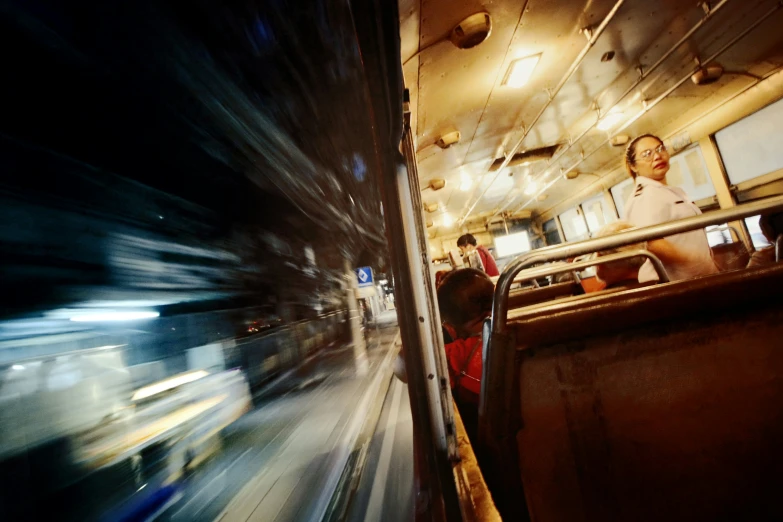 the interior of a bus at night with blurred windows