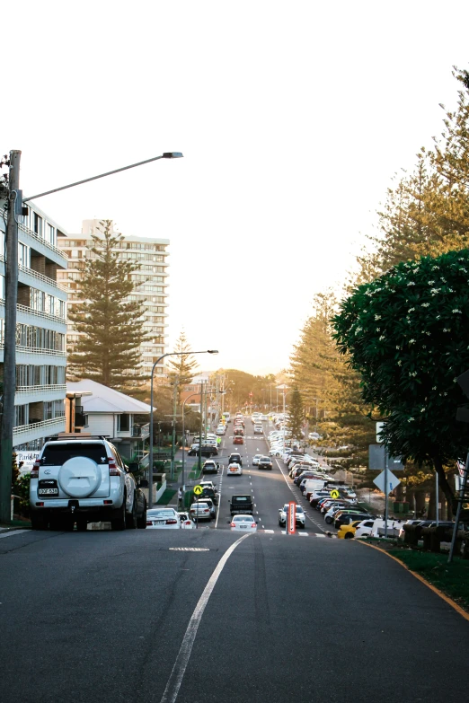 a very large city street with cars parked at the curb