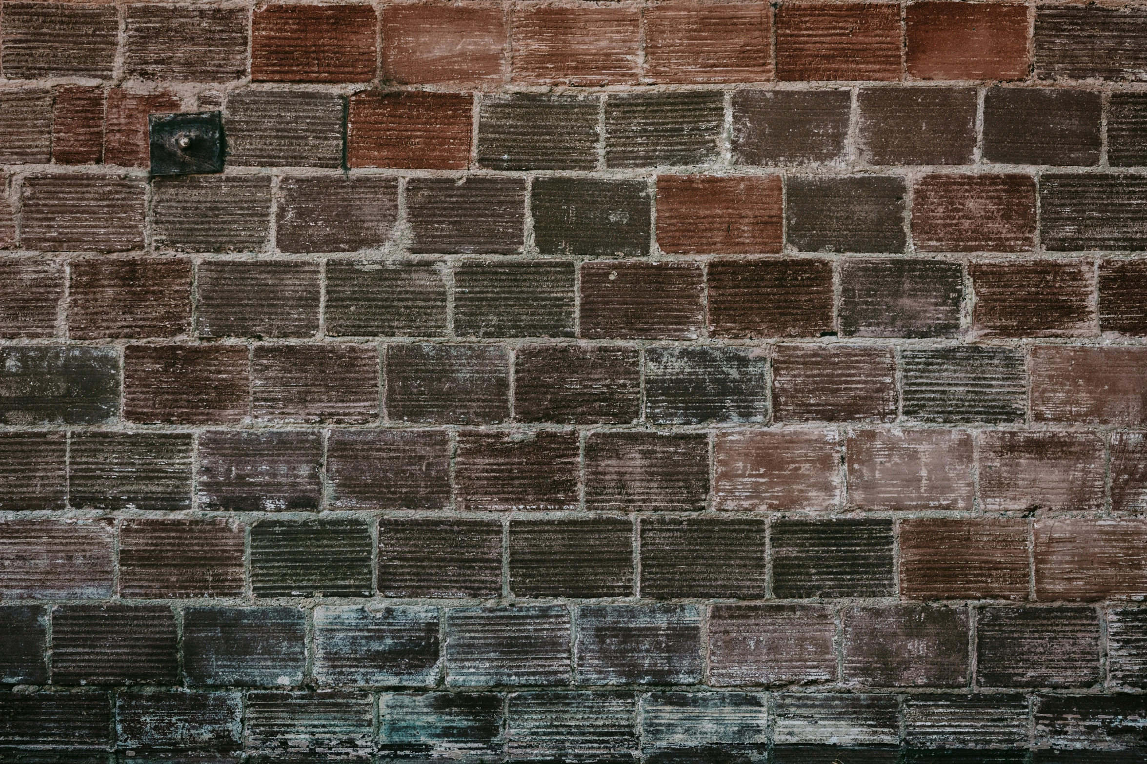 a bench sitting in the corner of a brick wall