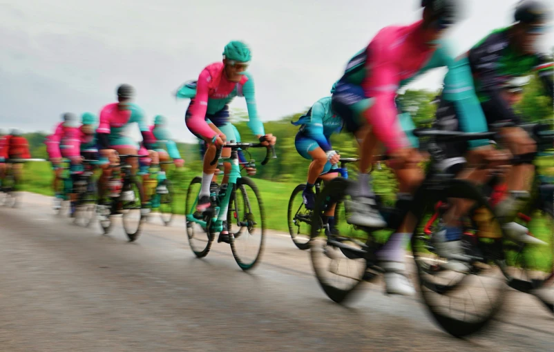 a group of bicyclists ride down the road