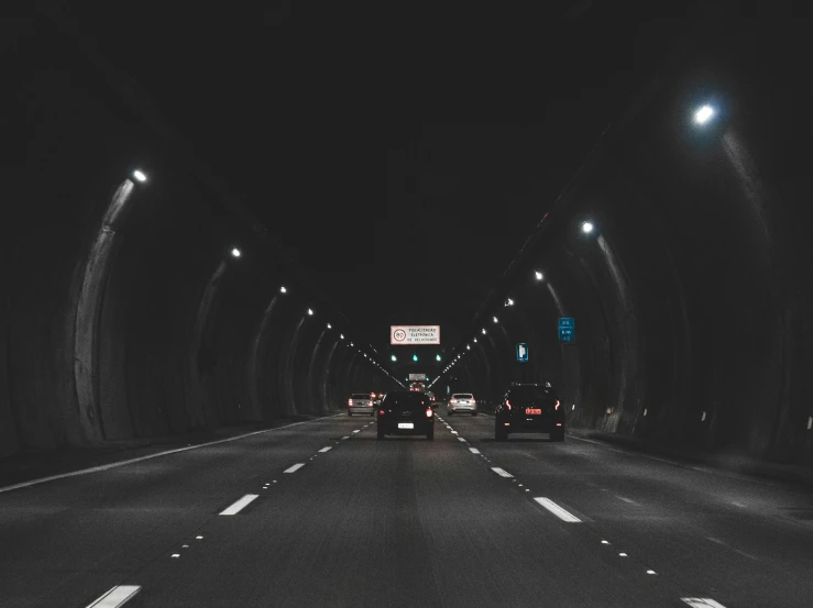 cars driving through a tunnel at night