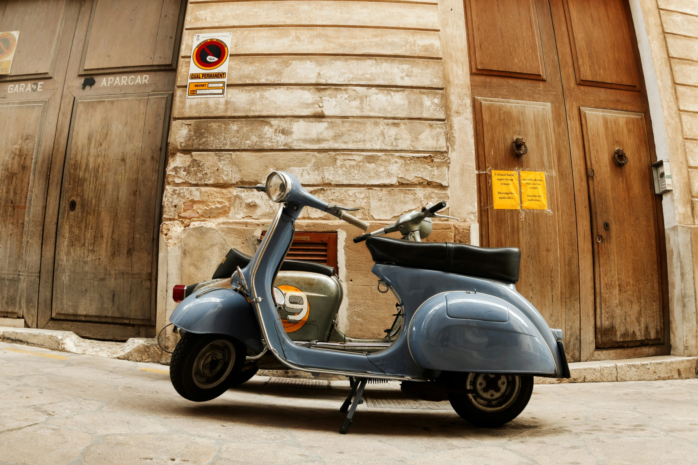 a blue moped is parked in front of a building