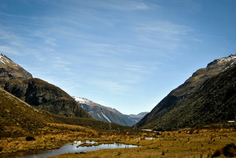 a valley is surrounded by mountains and grassy areas