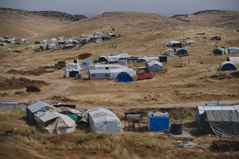 several tents are set up outside a mountainous area