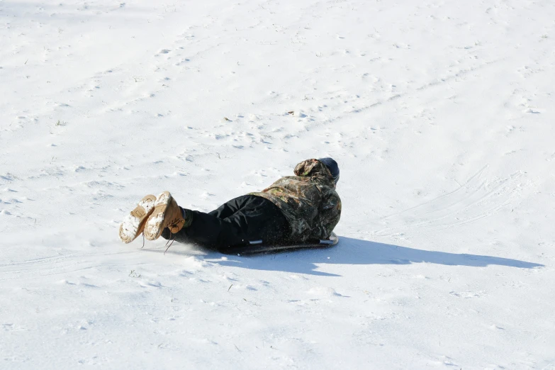 there is a snowboarder laying down in the snow