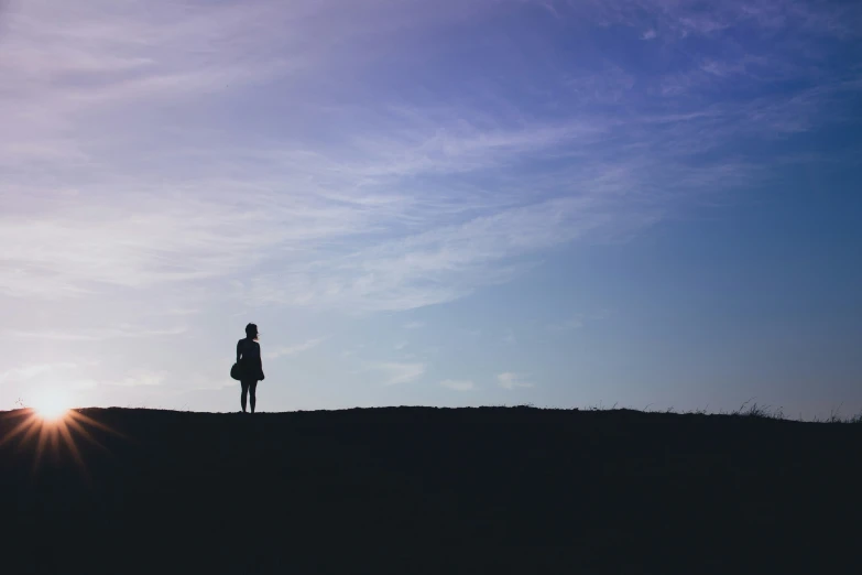 a person standing in the middle of a sunset