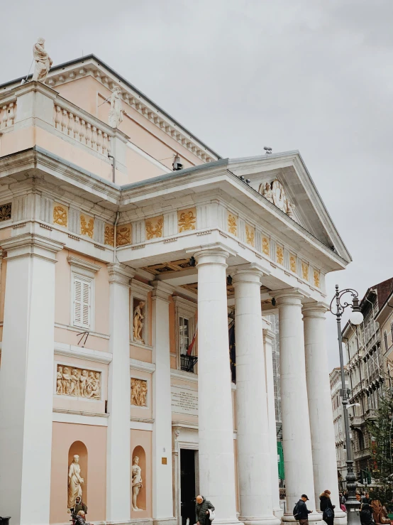 a stone building with pillars with people inside